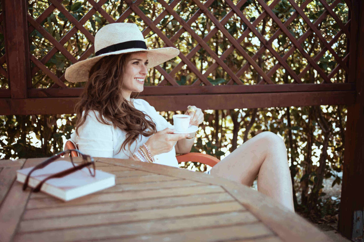 relaxed stylish woman in white shirt sitting at table