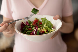 crop,close,up,of,young,caucasian,pregnant,woman,hold,bowl
